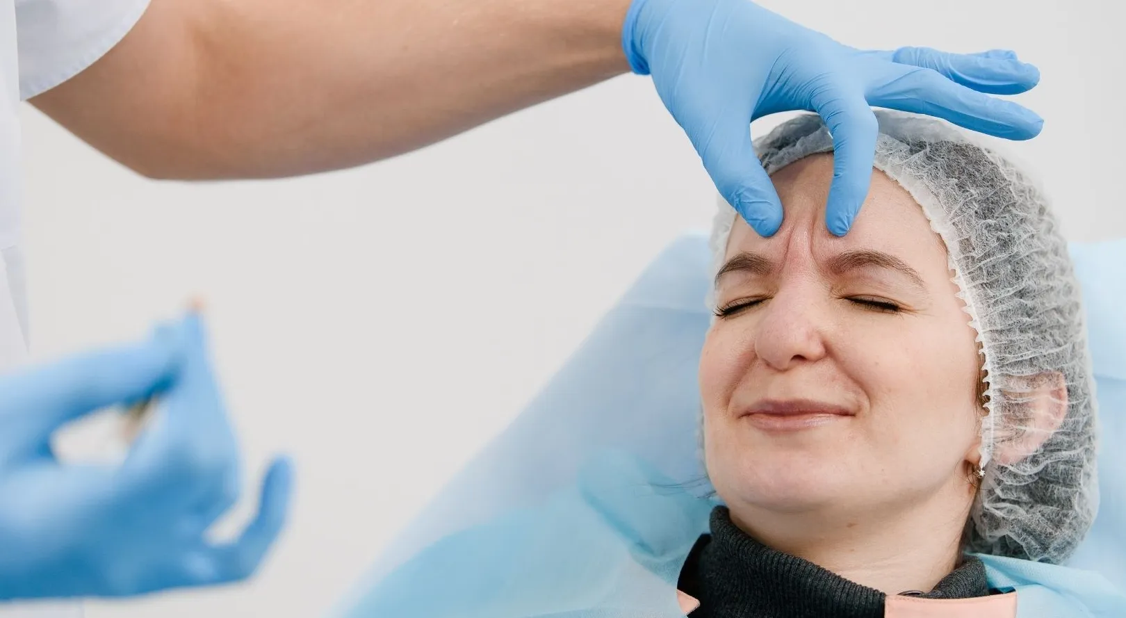 Profissional de estética preparando paciente feminina para receber toxina botulínica nas linhas de expressão