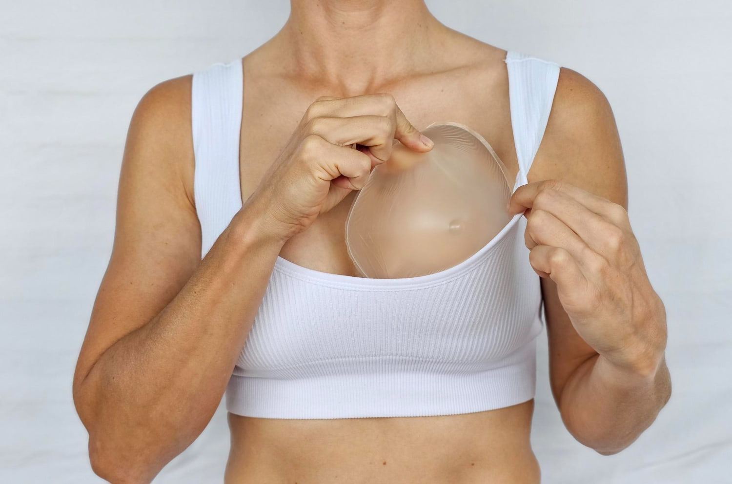 Mulher segurando próteses de silicone para implantar nas mamas